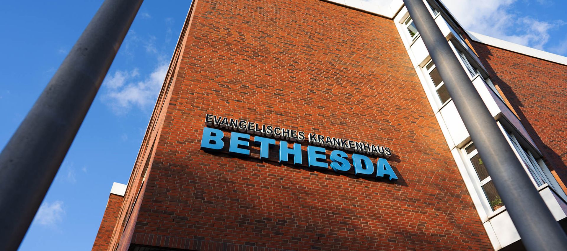 Schriftzug Evangelisches Krankenhaus Bethesda an der Fassade des Krankenhausgebäudes.