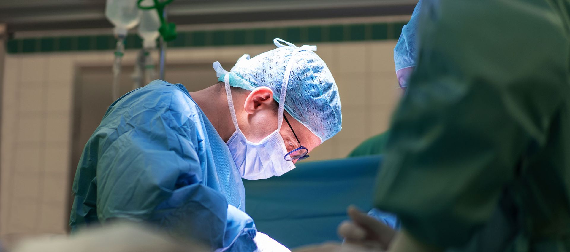 Prof. Dr. Simon Schimmack in OP-Kleidung, konzentriert bei einem chirurgischen Eingriff im Operationssaal.